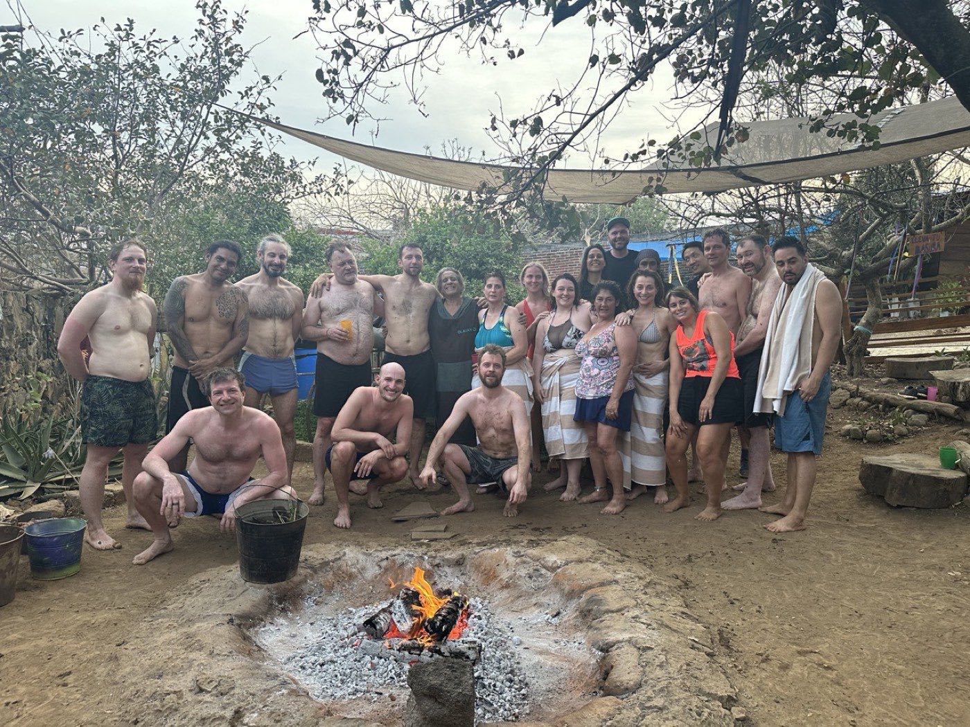 Group outdoors around the fire, many in swimwear