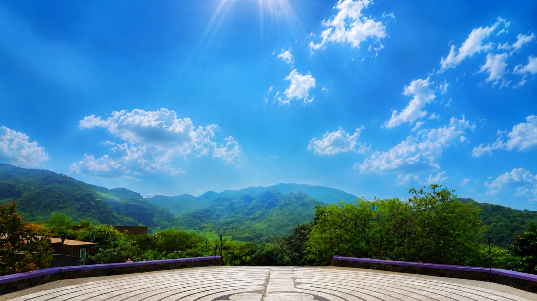The green mountains of Tepoztlán under a bright blue sky, seen from the retreat’s labyrinth terrace