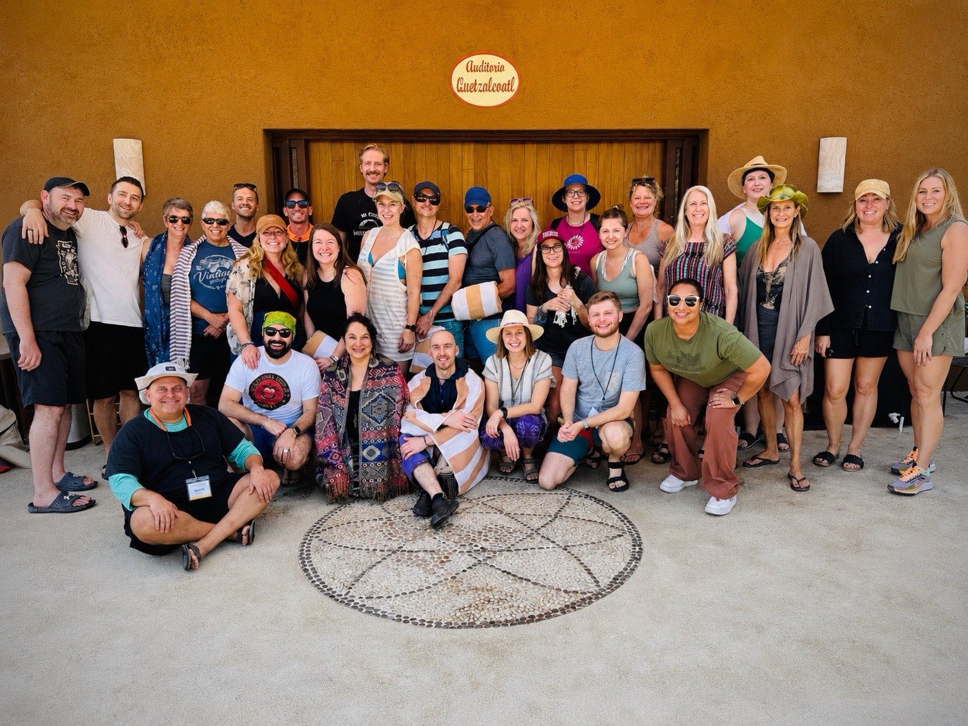 Group outside the doorway, circular stone pattern in front