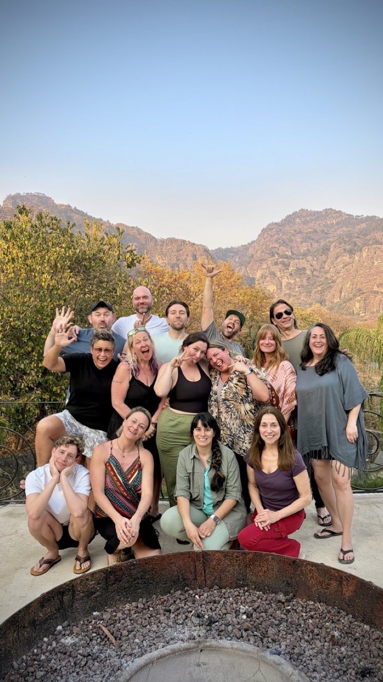 Group posing on a terrace at golden hour, the mountains behind